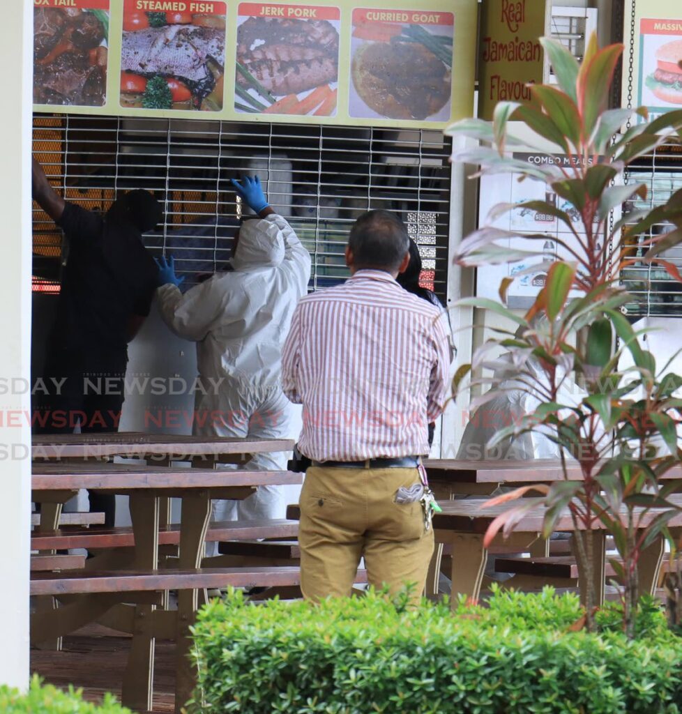 Crime scene investigators collecting evidence at the Breakfast Shed on Wrightson Road, Port of Spain after one man was killed and another injured after gunmen attacked them on Monday morning.  - File photo