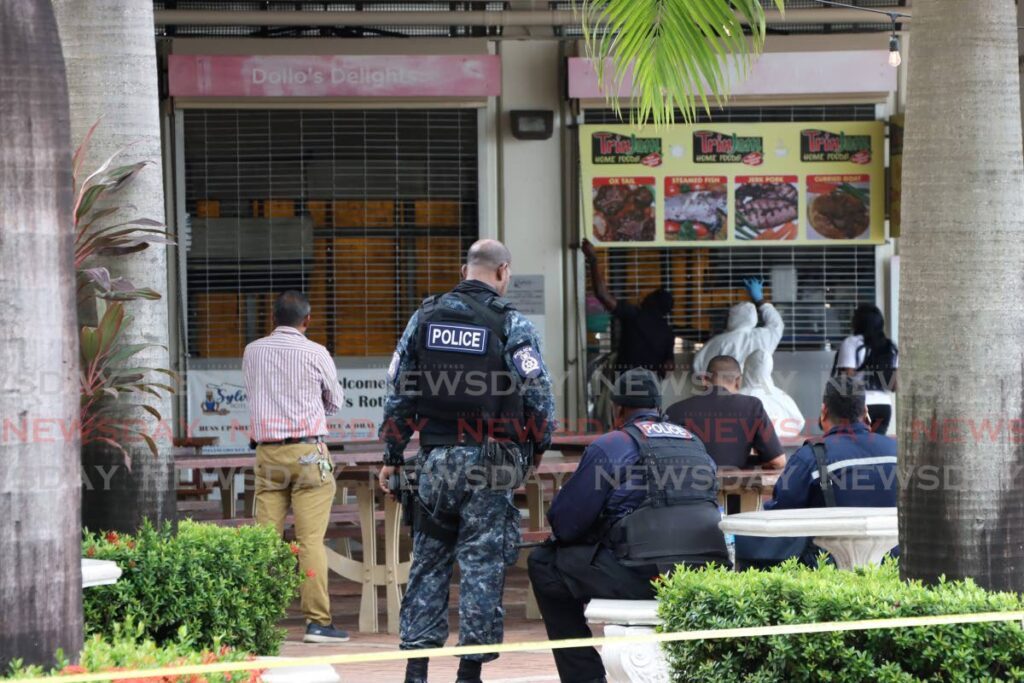 Police on the scene of the crime where two people were shot on Monday at the Breakfast Shed on Wrightson Road, Port of Spain.   - Faith Ayoung