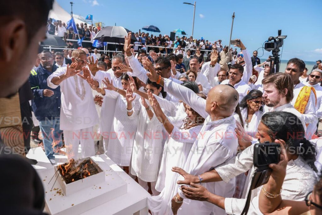 FINAL BLESSING: Relatives of former prime minister Basdeo Panday say a final prayer before his cremation at the Shore of Peace cremation site in La Romaine on January 9.  - Photo by Jeff K. Mayers