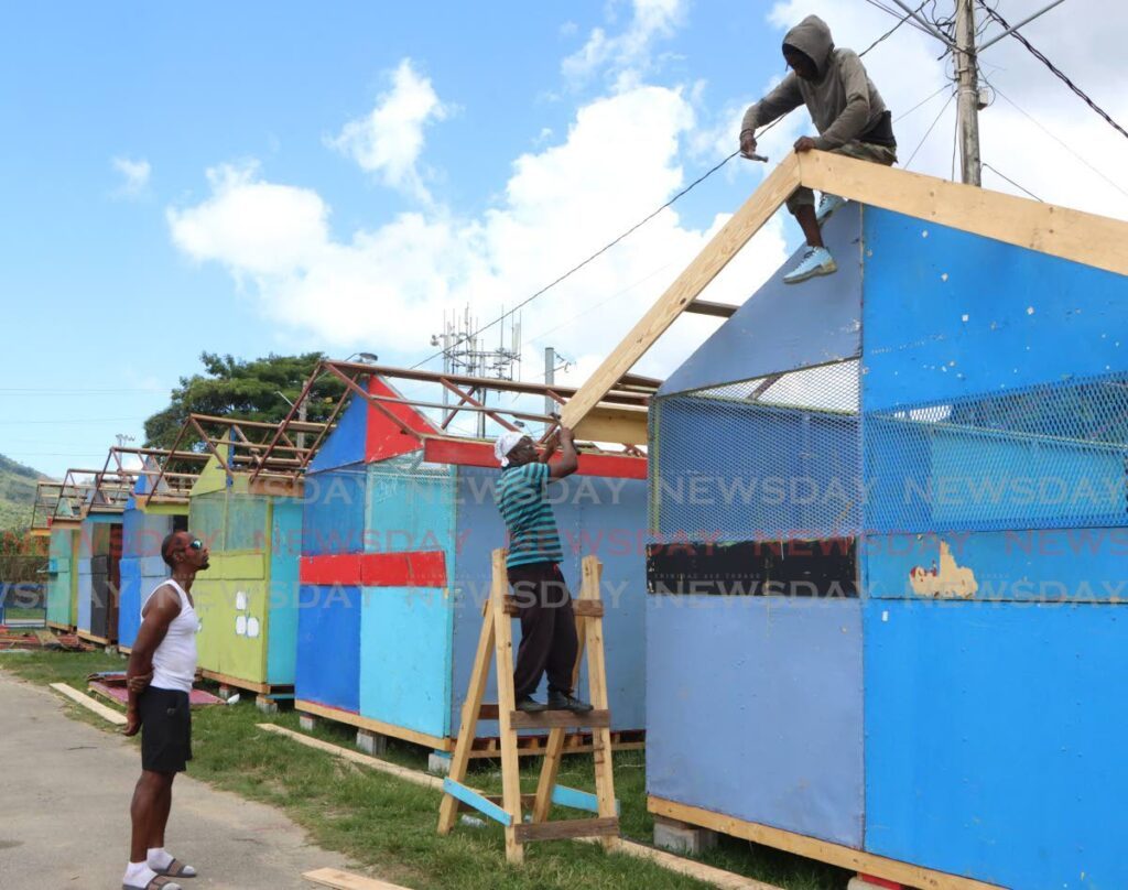 BACK TO WORK: Workmen construct a Carnival vendors' booth at the Queen's Park Savannah on Thursday. Construction only resumed after security was beefed-up in the wake of the murder a week ago of a Carnival worker in the Savannah. - Photo by Angelo Marcelle