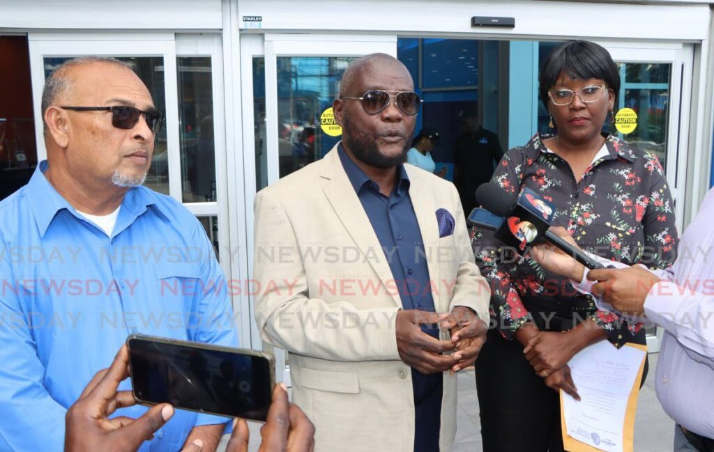 Scrap Iron Dealers Association president Alan Ferguson, centre, flanked by vice president Erros Seejattan, left, and secretary Willetta Wilson as they spoke with reporters in Port of Spain on Thursday. - Photo by Angelo Marcelle
