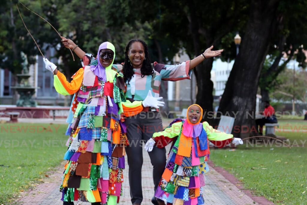 Kemoni Newton, left, Keiani Newton, right, with their mother Keomi Serrette, in Woodford Square. - Photo by Faith Ayoung