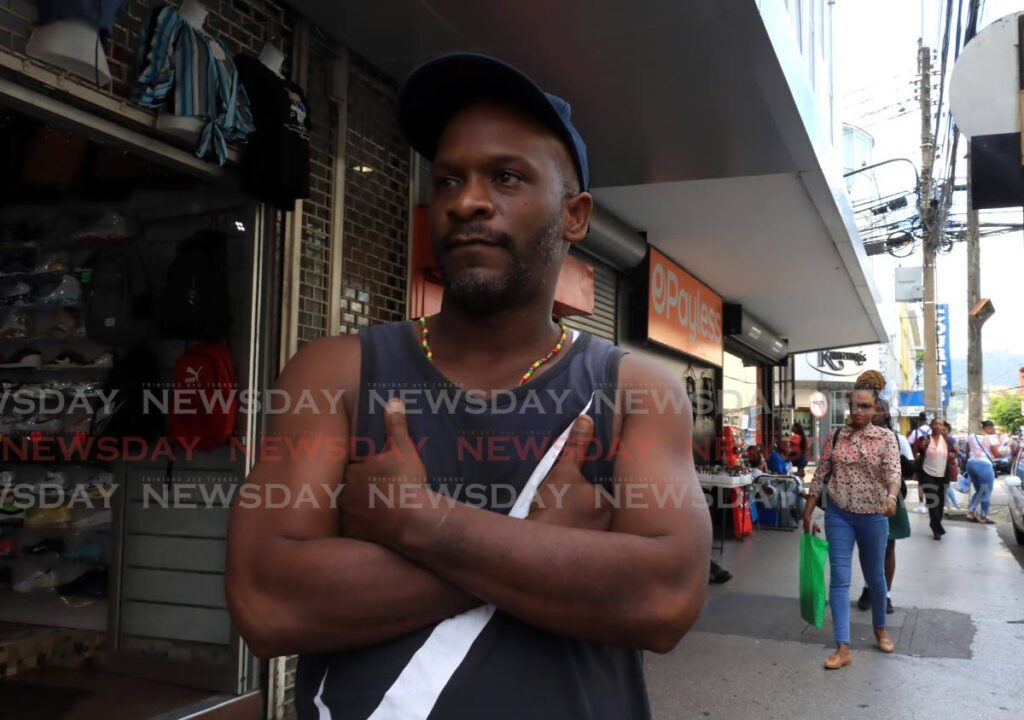 NOW APPROPRIATE: Come next Monday, this sleeveless jersey worn by Anthony Julien on Frederick Street in Port of Spain on Friday, will be adequate attire to access Government offices, thanks to a change in the dress code. - Photo by Roger Jacob
