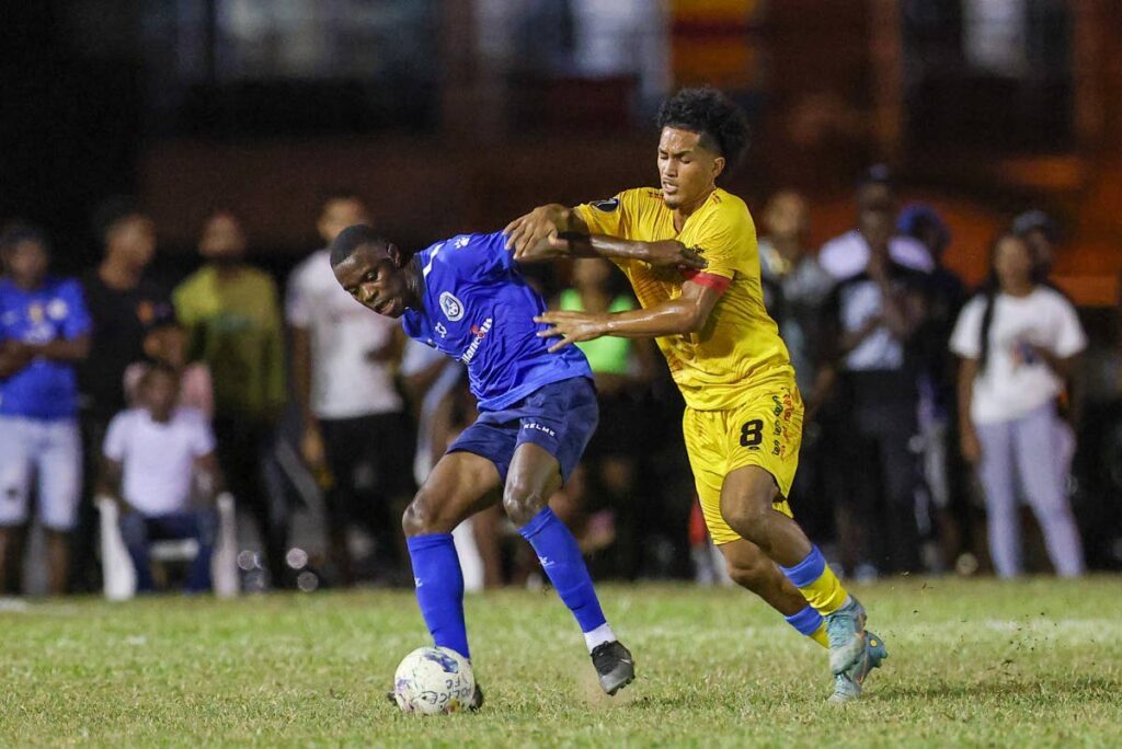  Police FC Jabari Mitchell (L) holds off AC PoS Michel Poon-Angeron to keep possession during the TT Premier Football League match at the Police Barracks on Friday in St James. - Photo by Daniel Prentice