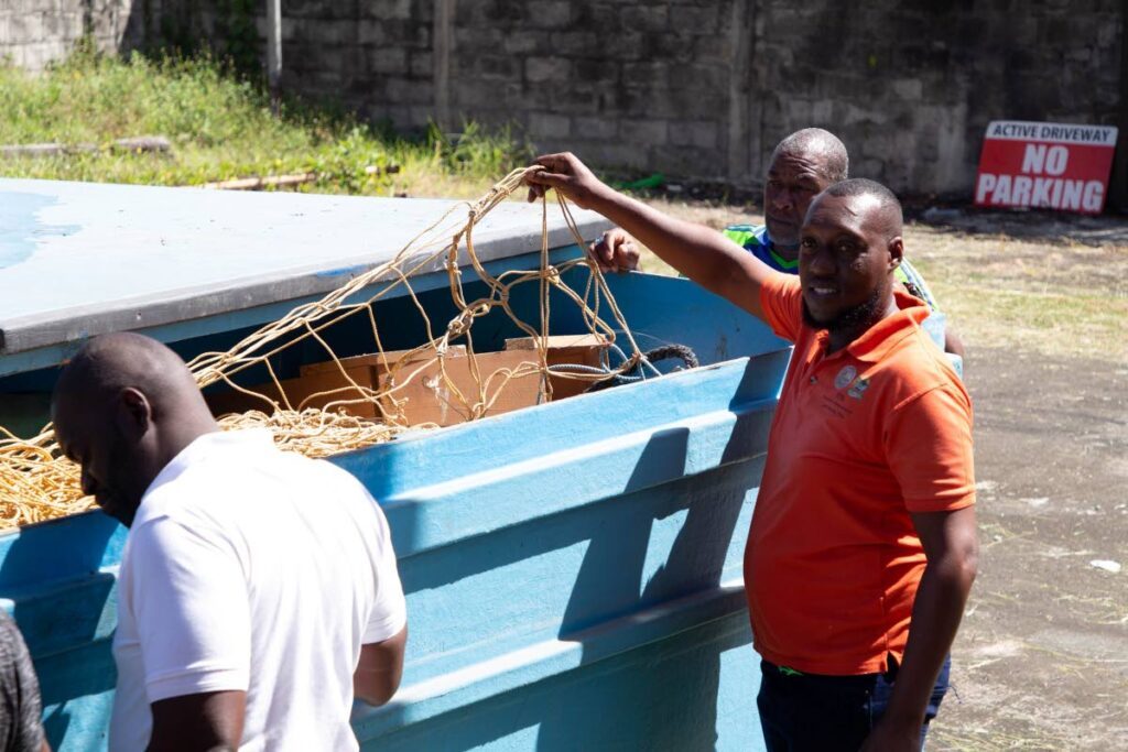 Fishermen inspect the set-nets in a container at Shaw Park, Tobago last Thursday. - Photo courtesy THA