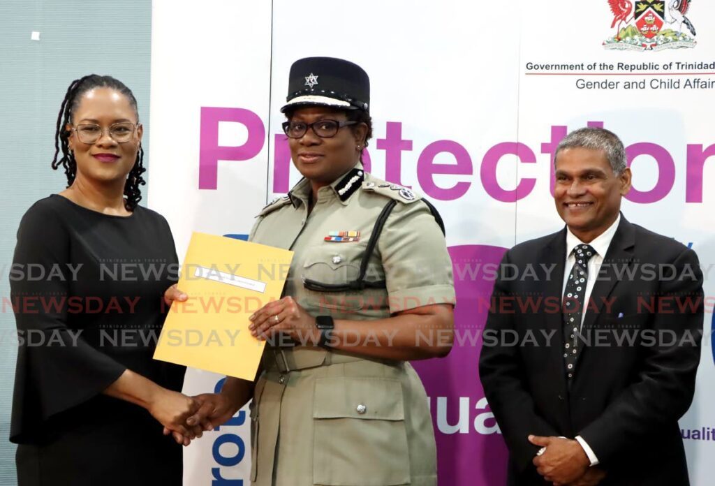 Minister in the Office of the Prime Minister Ayanna Webster-Roy, presents representative for law enforcement Commissioner of Police Erla Harewood-Christopher, with her letter of appointment for the Women, Peace and Security Advisory Group during the distribution ceremony at the Gender and Child Affairs, Office of the Prime Minister, St Clair. Looking on is acting permanent secretary Vijay Gangapersad.  - Photo by Ayanna Kinsale