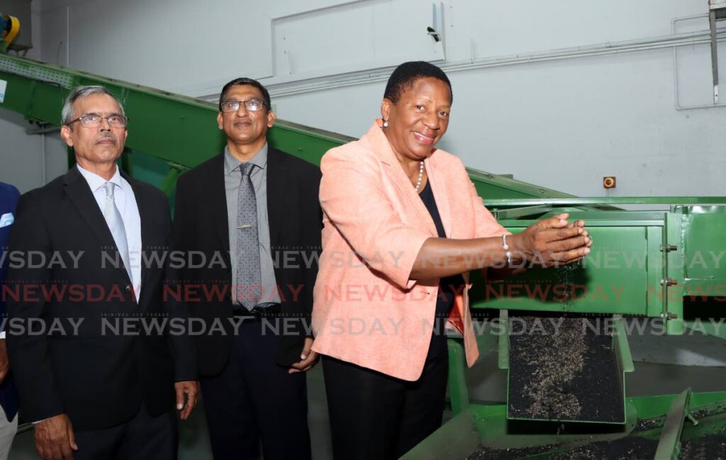 Minister of Planning and Development Pennelope Beckles-Robinson displays rubber crumbs during the launch of Cariri/UTT's Rubber Crumb Production Facility at UTT Campus, Gopaul Drive, Tarouba. Looking on are Professor Prakash Persad, Principal of UTT, and Keshore Lutchman, Deputy Permanent Secretary of the Ministry of Planning and Development. - Photo by Ayanna Kinsale