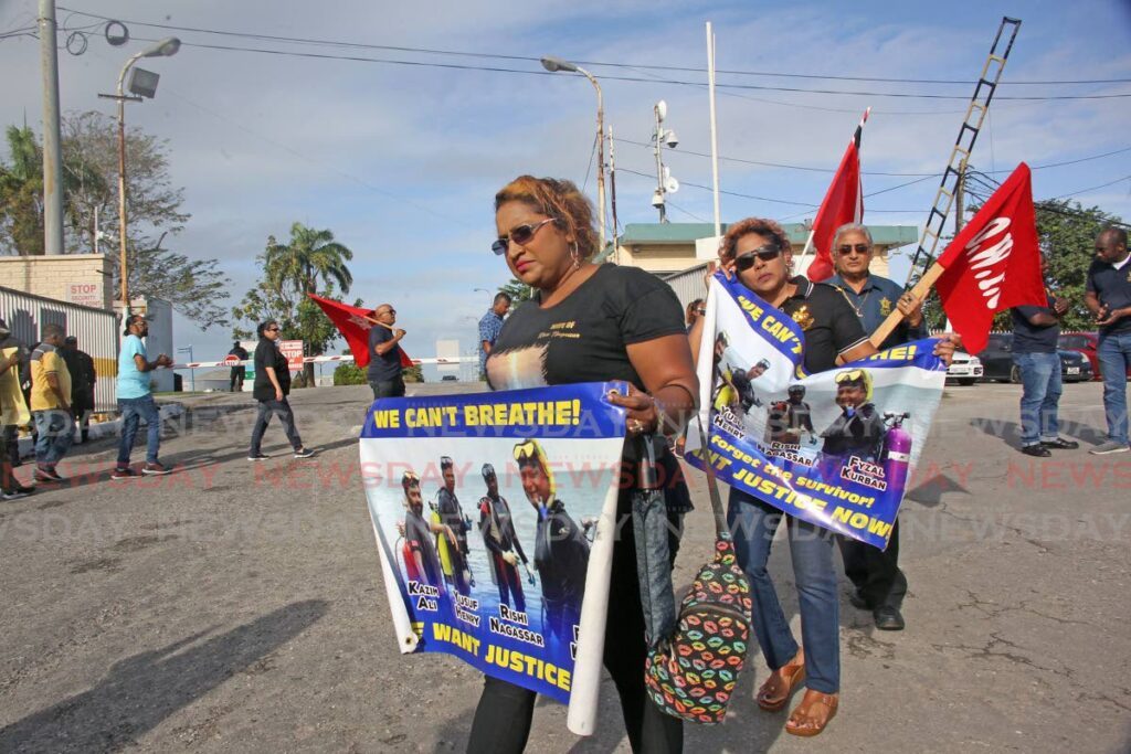 SEEKING JUSTICE: Vanessa Kussie, widow of diver Rishi Nagessar, walks ahead of Celisha Kurban, widow of diver Fyzal Kurban during a protest on Thursday outside the Pointe-a-Pierre head office of Paria Fuel Trading Co. - Photo by Lincoln Holder 