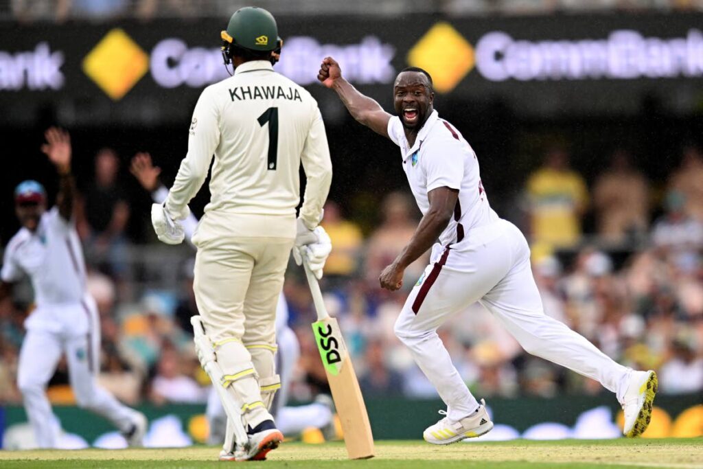 West Indies' Kemar Roach, right, celebrates after taking the wicket of Australia's Travis Head on the second day of their cricket Test match in Brisbane, Friday. - AP PHOTO