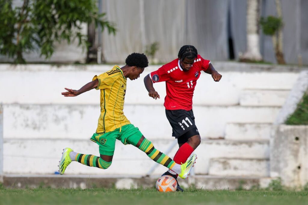 TT’s Malachi Webb (R) goes past Jamaica’s Jahmani Bell during Under-20 Practice Match at the UTT O’meara on Thursday.  - DANIEL PRENTICE