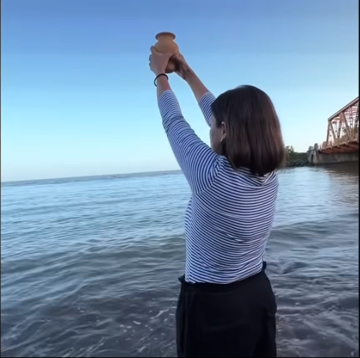 Mickela Panday scatters the ashes of her father, former prime minister Basdeo Panday, in the Gulf of Paria in this screenshot taken from her Facebook video. 
