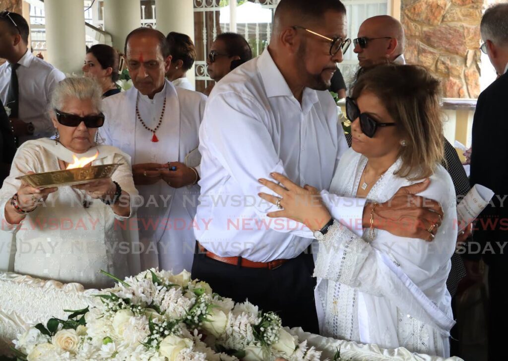 Ish Galbaransingh's widow Cheryl Galbaransingh being comforted by former government minister Carlos John during Galbaransingh's funeral on Tuesday.  - ROGER JACOB