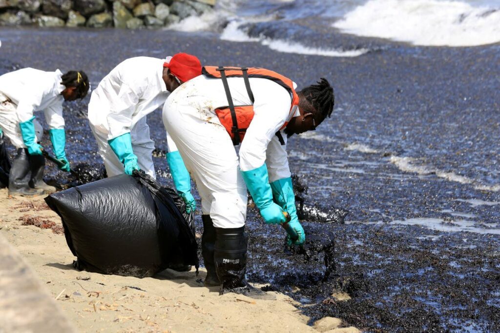 Workers remove oil-stained sand near Canoe Bay, Toabgo during clean-up operations on February 8. - Photo courtesy THA
