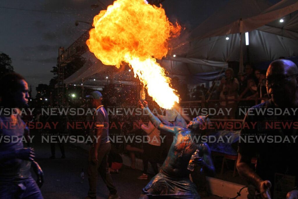 A blue devil lights up the pre-dawn sky with his fire-breathing at the Canboulay Riots re-enactment on Piccadilly Street, Port of Spain on February 9. - Photo by Faith Ayoung
