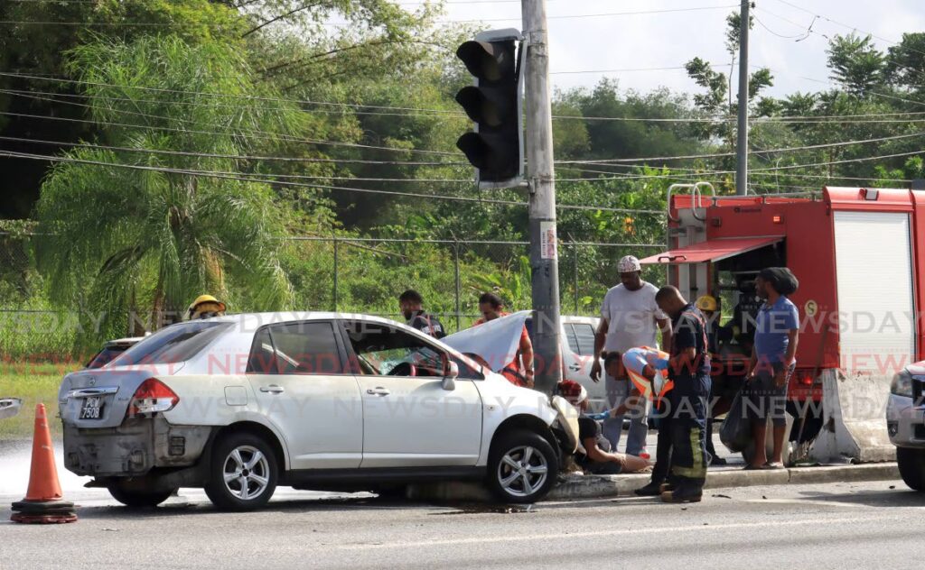 First responders attend to an accident victim near Piarco traffic lights on the Churchill Roosevelt Highway on February 10. - ROGER JACOB