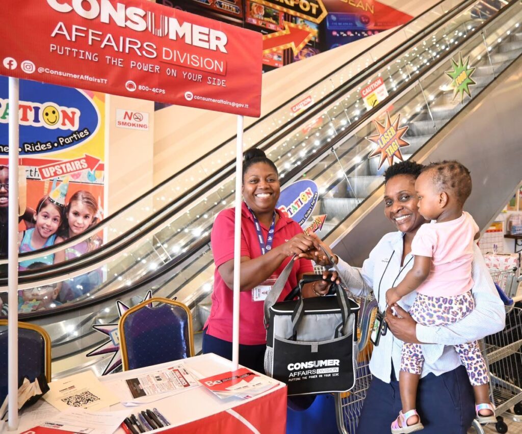A representative from the Consumer Affairs Division hands over a token to a supermarket customer at their BeEducated, BeEmpowered outreach campaign at Xtra Foods Supermarket, Endeavour on February 9. - Photo courtesy the Consumer Affairs Division of TT's Facebook page