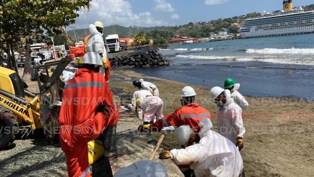A crew works to clean up an oil spill affecting Tobago's western coastline as a cruise ship docks at the Port of Scarborough nearby on Sunday. - File photo by Jaydn Sebro