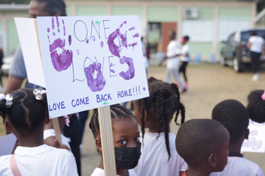 A Patience Hill Government Primary School student holds a placard promoting peace, during a walk against violence on Wednesday morning. - Photo courtesy THA