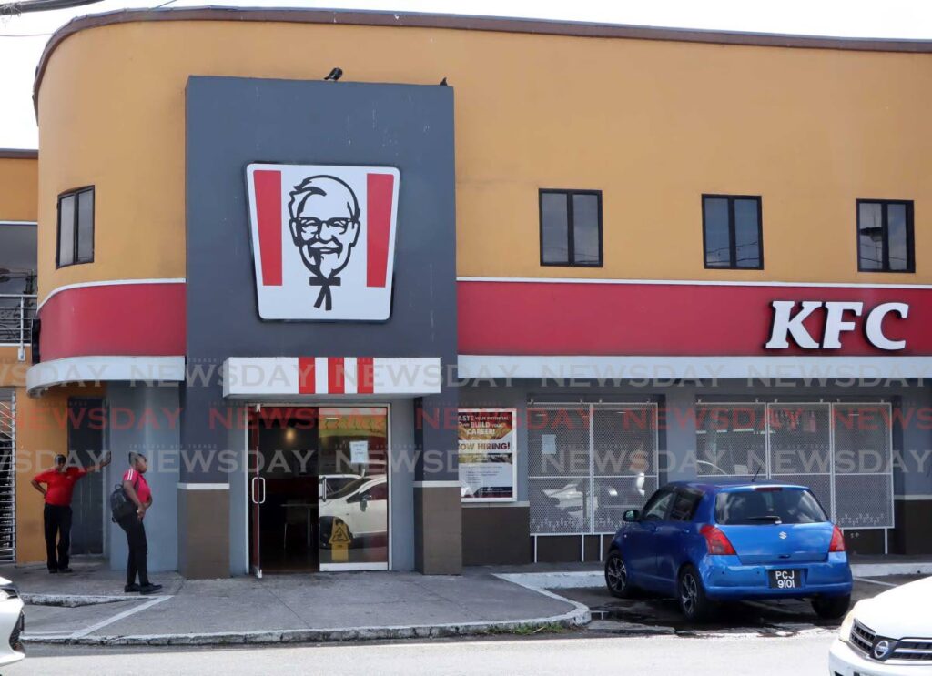 KFC workers stand outside the building on Bonne Aventure and Harmony Hall Roads, Gasparillo, where customer Luka Goring was shot and killed after an altercation with an unidentified man on Friday night.  -  