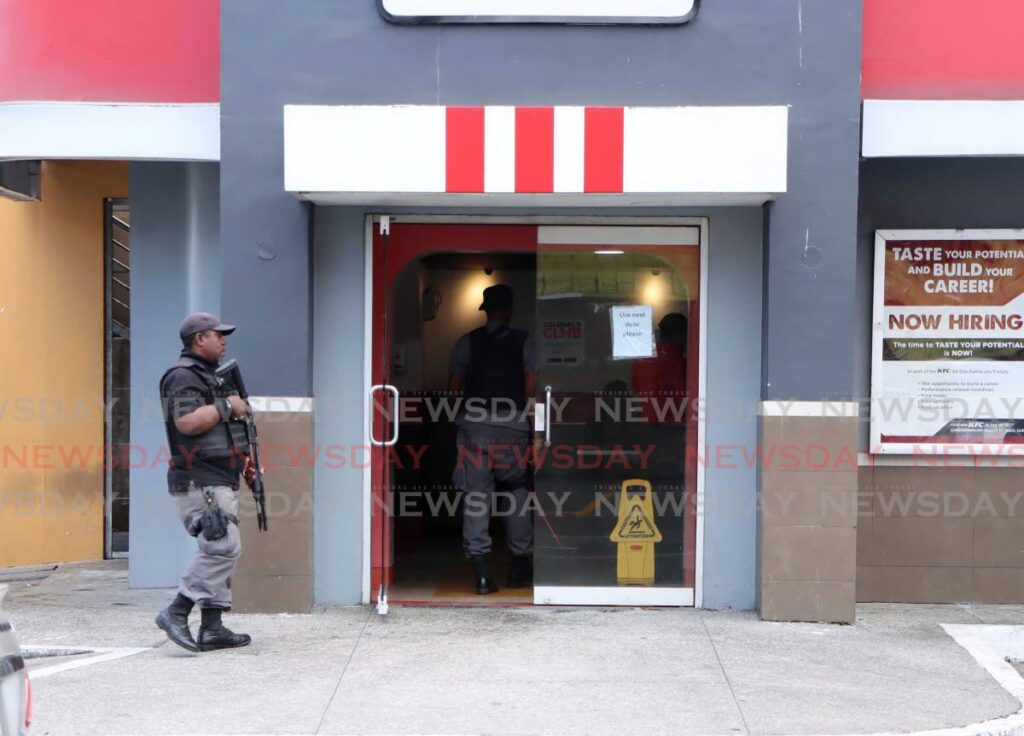 An Amalgamated security guard enters the KFC outlet, Gasparillo on February 17, after the fatal shooting of Luka Goring following an altercation with another man on February 18. - Photo by Ayanna Kinsale