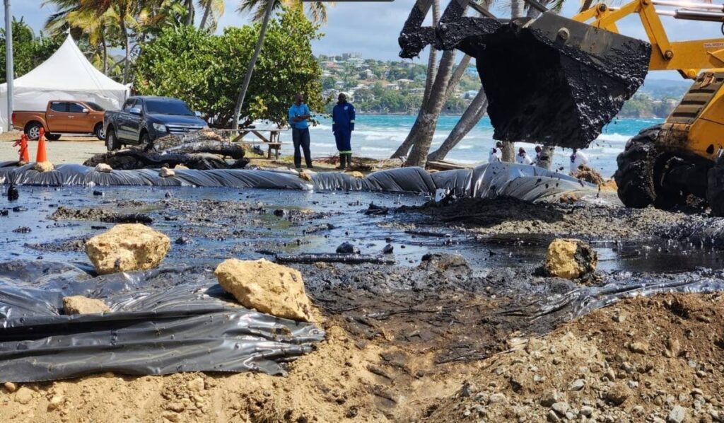 A backhoe helps in the clean-up of an oily substance along the coast in Tobago.  - Photo courtesy TEMA