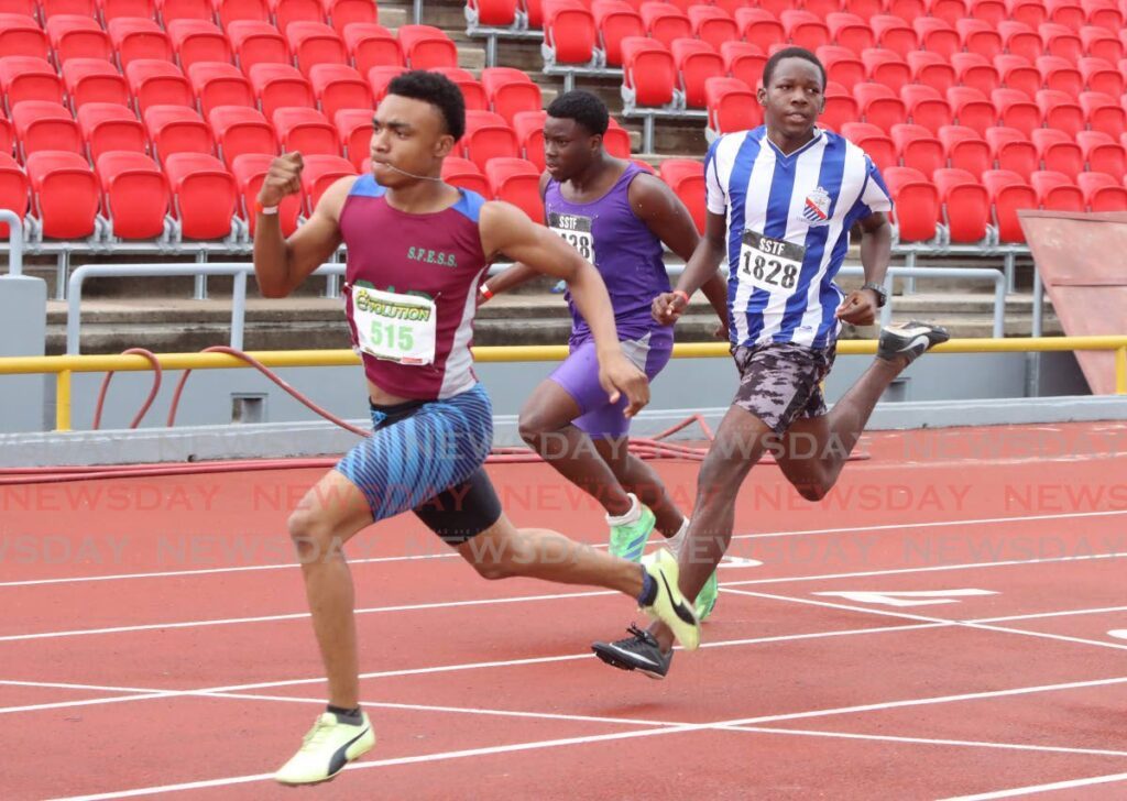 Athletes compete in the Boys’ 17+ 100m race during day one of the Secondary School Track and Field National Championships at the Hasely Crawford Stadium, Port of Spain, on Tuesday.  - AYANNA KINSALE