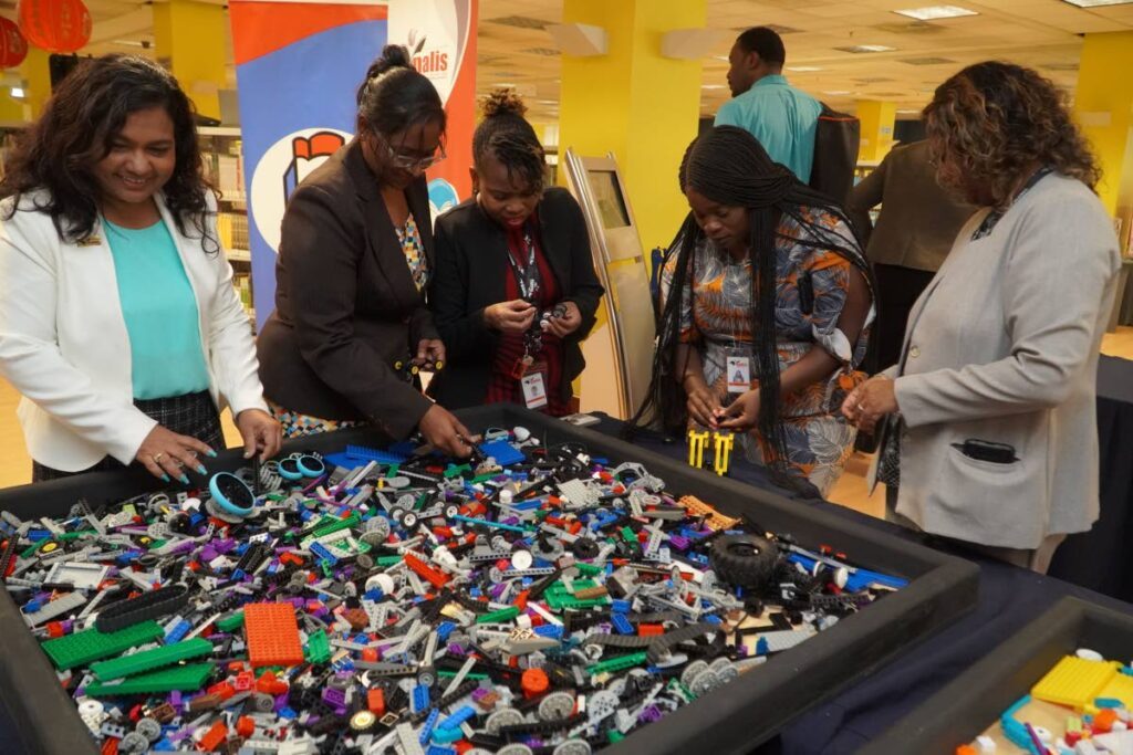 Staff at the National Library, Port of Spain, seeks to build models using the Lego bricks in the Niherst/Nalis Science Corner. - 