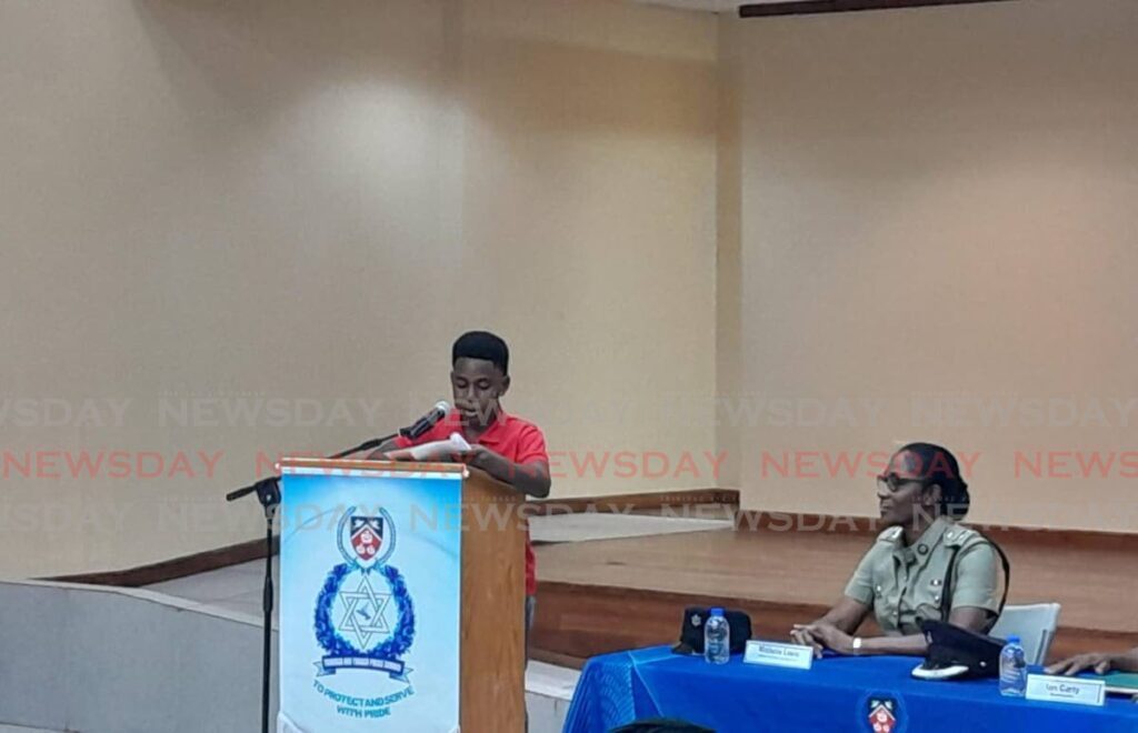 Israel Rodney, 12, a member of the Malabar Police Club, gives a speech at the town meeting as Police PRO Michelle Lewis looks on. - Photo by Joey Bartlett