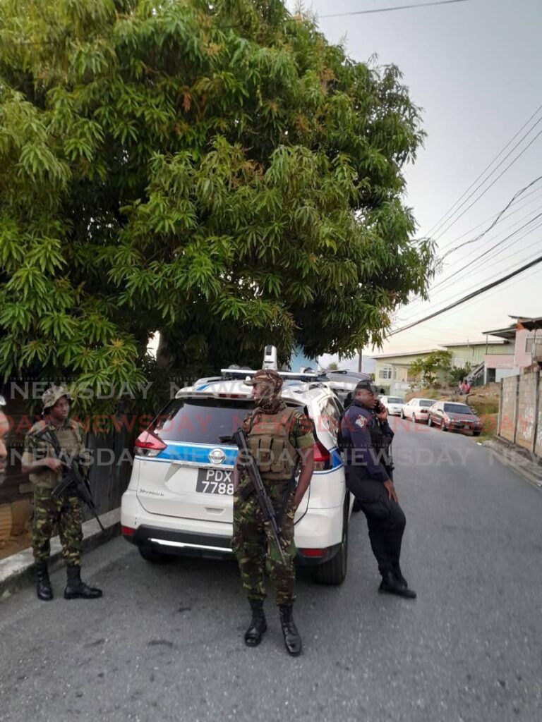 Police and soldiers at Mapp Trace, Laventille where a schoolboy was killed in a drive-by shooting on February 22.  - Photo by Gregory McBurnie 