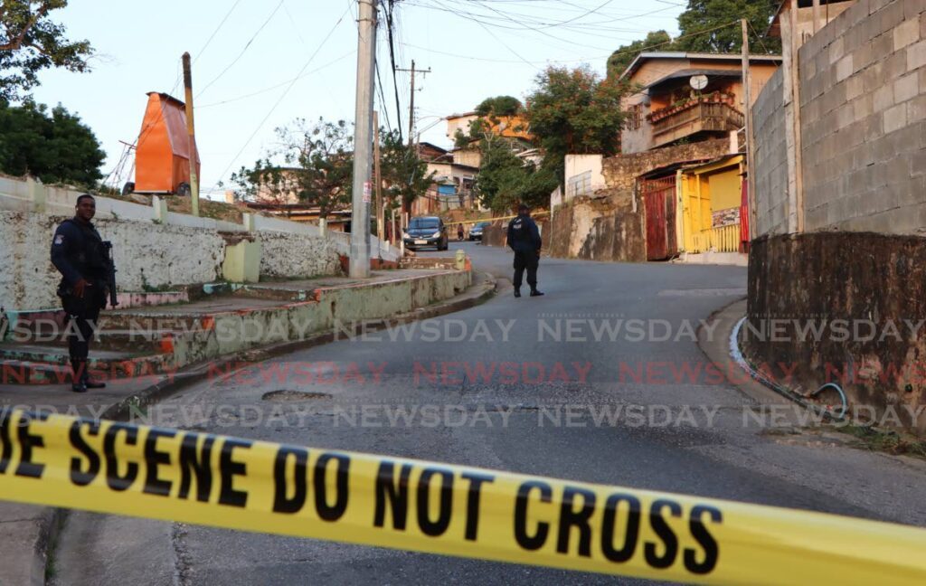 Police on the scene where Ezekiel Paria, 11, was shot dead during a drive-by at Laventille Road, East Dry River, Port of Spain, on February 22. - Photo by Angelo Marcelle