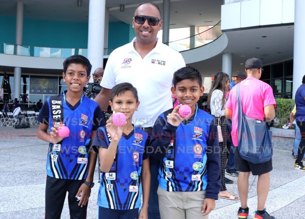 Cricketer Samuel Badree takes a photo with young cricketers (from left) Aidan Kunjan, 10, Aidan Khan, 8, and Sanjeev Ramjattan at the ICC T20 World Cup countdown event at C3 Mall, San Fernando on February 22. - Photo by Ayanna Kinsale