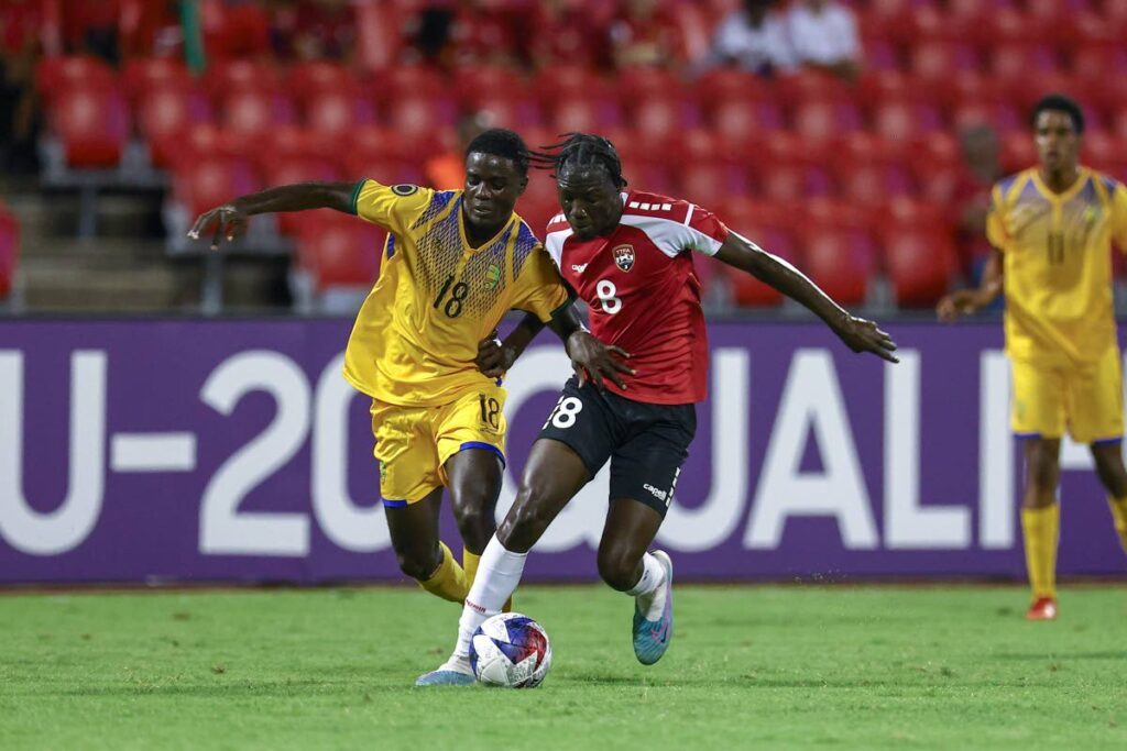 TT's Abayomi George (R) and St Vincent and the Grenandines' Mackellie Ferdinand battle for the ball during the Concacaf Under-20s Championship Group D qualifier match, on Friday, at the Hasely Crawford Stadium, Port of Spain.   - DANIEL PRENTICE