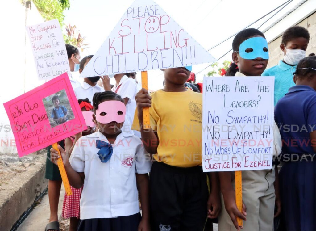 STOP KILLING CHILDREN: Children hold their placards during a protest at Mapp Trace, Laventille Road, East Dry River where Ezekiel Paria, 12, was shot and killed last Thursday.  - AYANNA KINSALE