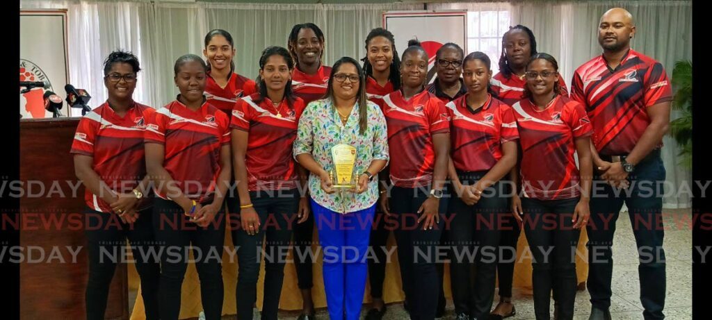 Former WI and TT women’s captain Anisa Mohammed, centre, shows off a plaque presented by the TTCB for her stalwart performances over the past two decades. Mohammed retired from international cricket in January. Standing along with Mohammed are current Red Force women players, who begin their Super50 quest on Monday. - Photo by Jonathan Ramnanansingh