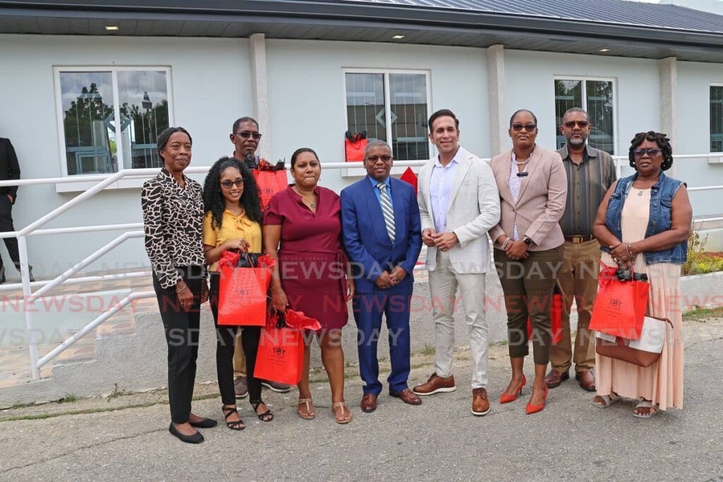 Faris Al-Rawi, Minister of Rural Development and Local Government, San Fernando mayor Robert Parris, San Fernando East MP Brian Manning, Desdra Bascombe, PS in the ministry and Patricia Alexis, chairman of the Rural Development Co,   with recipients of keys to the local economic development booths at Parakeet Blvd, Pleasantville which were handed over on February 28. - Photo by Lincoln Holder 