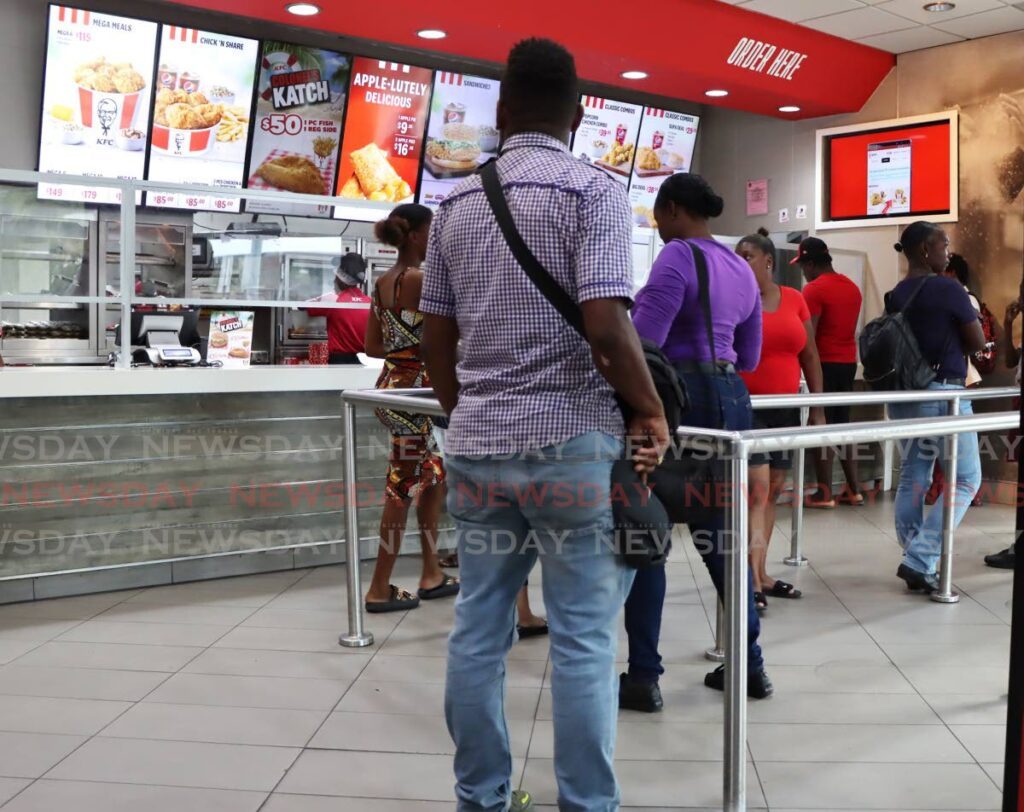 Customers stand in line at KFC, Independence Square, Port of Spain. - Photo by Ayanna Kinsale