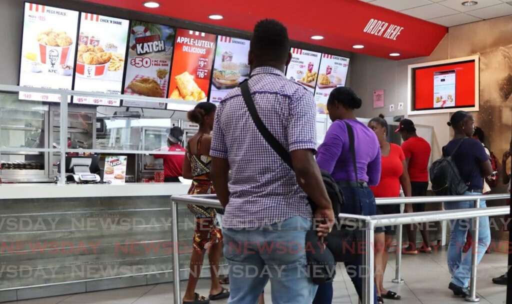 Customers stand in line at a KFC branch. - File photo by Ayanna Kinsale