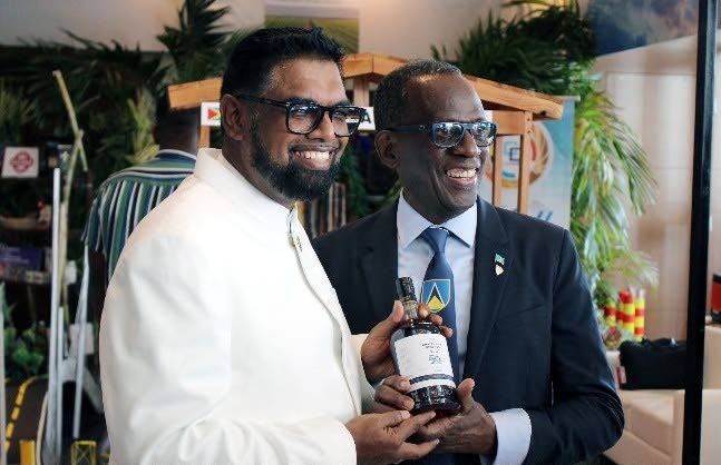 St Lucia Prime Minister Philip J Pierre presents a bottle of Caricom's 50th-anniversary rum blend to Guyanese president and new Caricom chairman Dr Irfaan Ali during the 46th Regular Meeting of the Conference of Caricom Heads of Government in Guyana earlier this week. - Photo courtesy Caricom