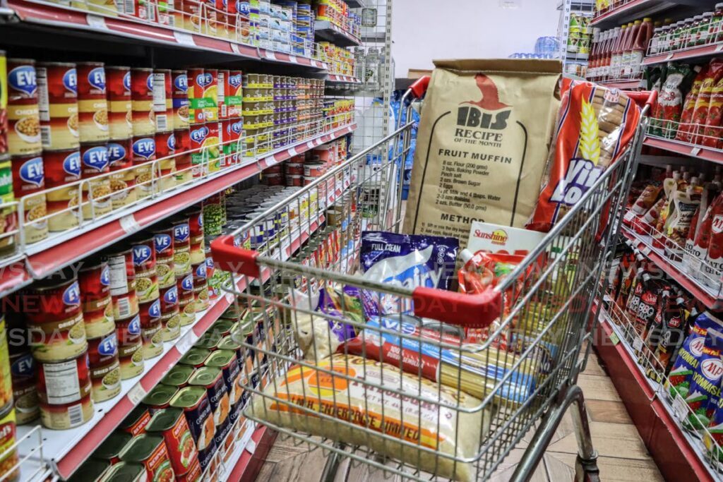 Shopping cart filled with essential food items at a grocery store in Port of Spain. - File photo by Faith Ayoung