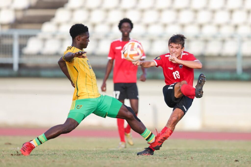 TT’s Michael Chaves (R) shoots wide while under pressure from Jamaica’s Rolando Barrett during an international U-20 practice match at the Larry Gomes Stadium on February 1 in Malabar. - Photo by Daniel Prentice