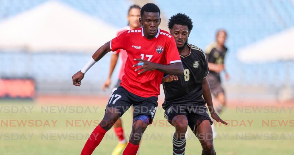 TT’s Kaihim Thomas, left, evades Jamaica’s Alex Marshall during a friendly match at the Hasely Crawford Stadium, Port of Spain on March 1. - Photo by Daniel Prentice