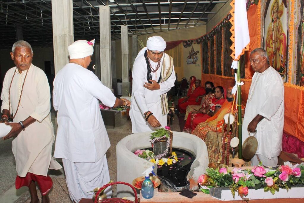 Pundit Satyanand Mahabir Dubey, centre, makes offering on a Shiv lingam at a past Shivratri event. - 