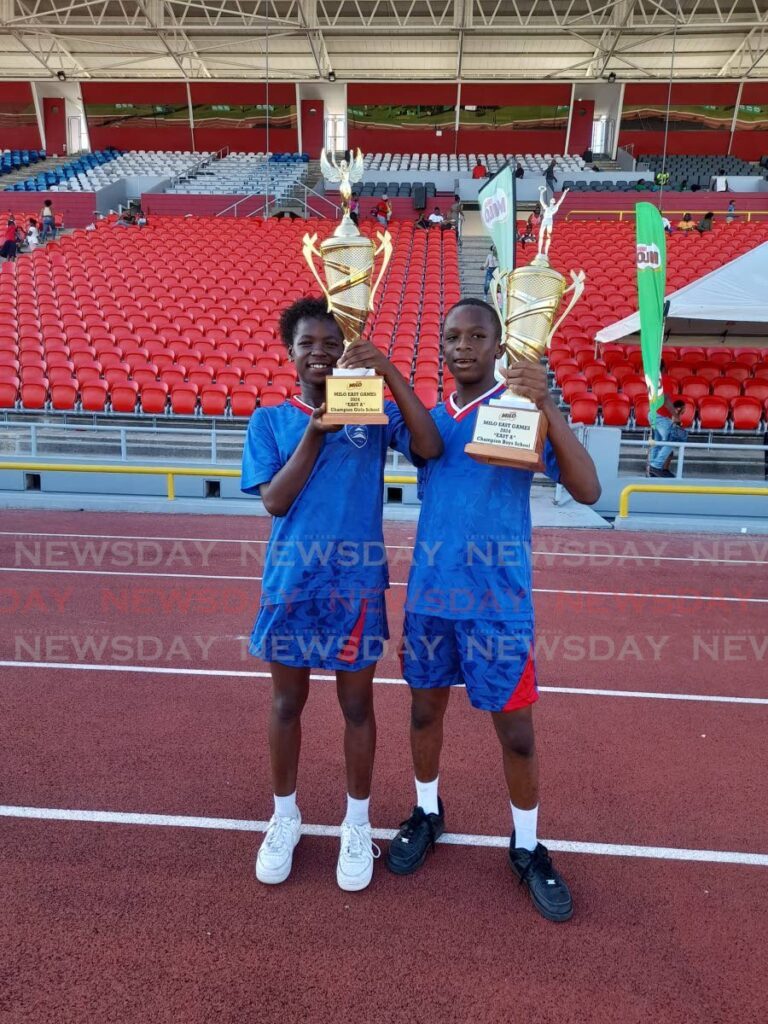 Kemecia Agard (L) and Josiah Kaiton (R) celebrate with their school's championship trophies at the Milo Primary School Games on March 6, 2024 at the Hasely Crawford Stadium, Mucurapo. In the under-15 age group, Agard and Kaiton won the respective Victrix and Victor Ludorum trophies for St Dominic's RC School in the East 'A' zone. - Photo by Roneil Walcott