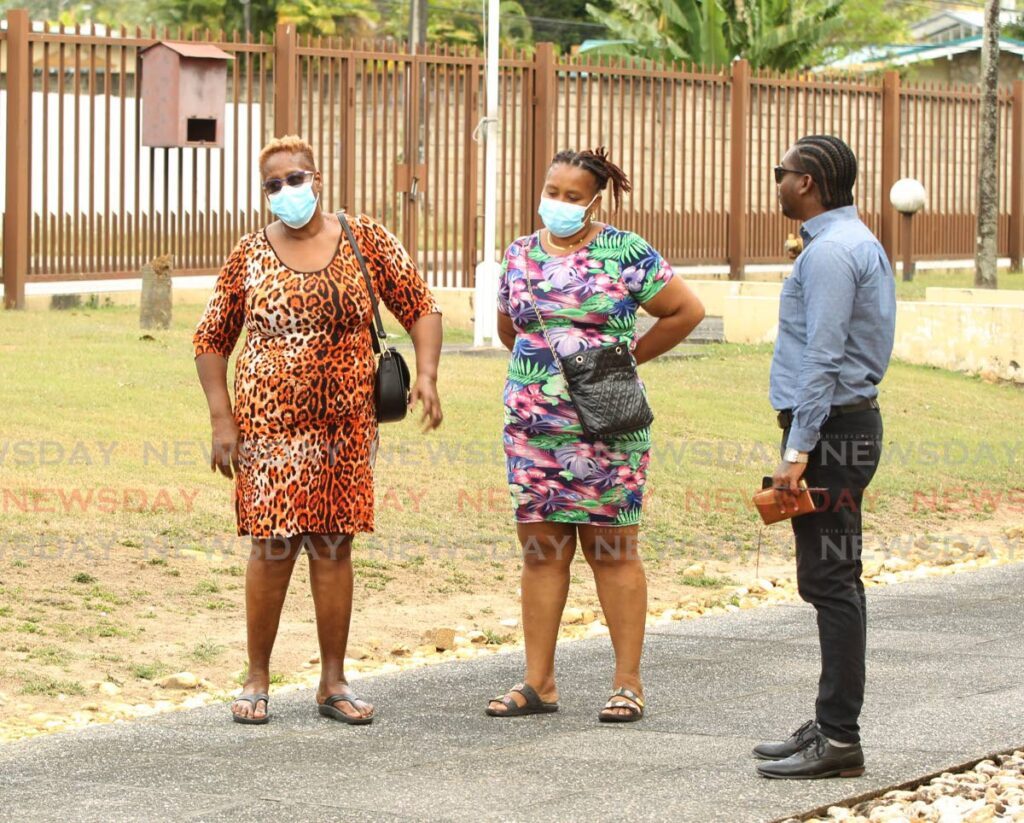 From left, Velerie Decle and Pachilli Douglas, wife and daughter respectively, of murdered URP formeman Vince Decle, 54, speak with Newsday reporter Joey Bartlett at the Forensics Science Centre in St James on March 6.  - Photo by Faith Ayoung