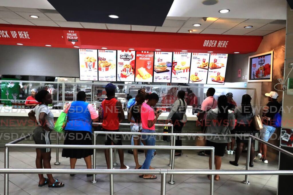 News of KFC boycott has been gaining hype on social media feeds for the past week, as Prestige Holdings Limited introduced increased pricing for KFC signature items, however as seen in this photograph many still opted for the popular fast food dish at the Independence Square branch, Port of Spain on March 7. - Photo by Roger Jacob