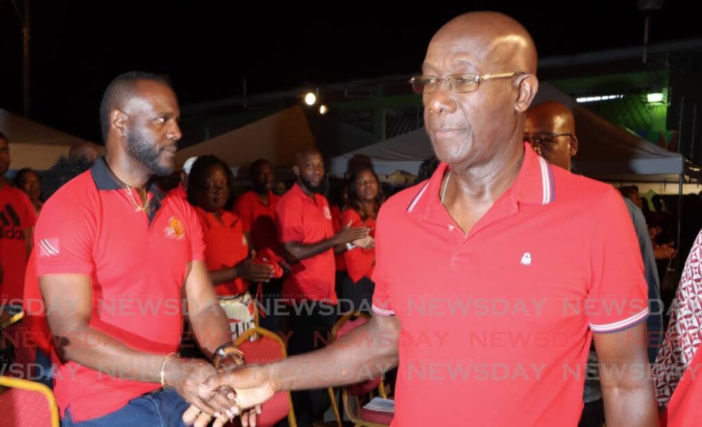 Prime Minister Dr Keith Rowley, right, greets Minister of Public Utilities Marvin Gonzales at a PNM political meeting at Tropical Angel Harps Pan Yard, Chaguanas, on March 7.  - Photo by Angelo Marcelle