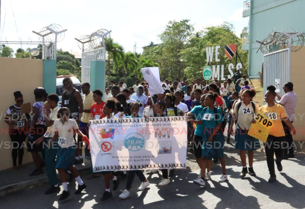 FOR PEACE: Students of the Morvant/Laventille Secondary School leave the school’s compound for the Stop the Violence Walk/Run in the Morvant community on Tuesday.  - Photo by Roger Jacob