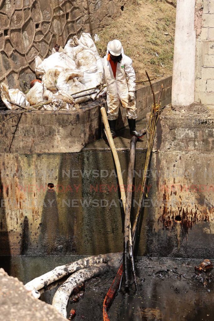 Contractors working for Heritage Petroleum engaged with cleaning the Tarouba river in the Vistabella area after an oil leak was detected and seeped into the river. - Photo by Lincoln Holder