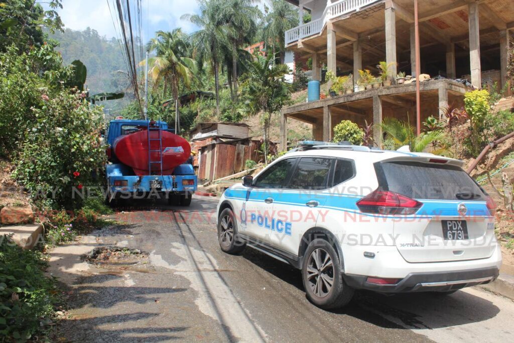 After a fire broke out at Powder Magazine Phase 1 on March 18, fire officers worked to keep the blaze under control. A WASA truck was also on-site to provide an additional water supply.  - Photo by Sydney Joseph