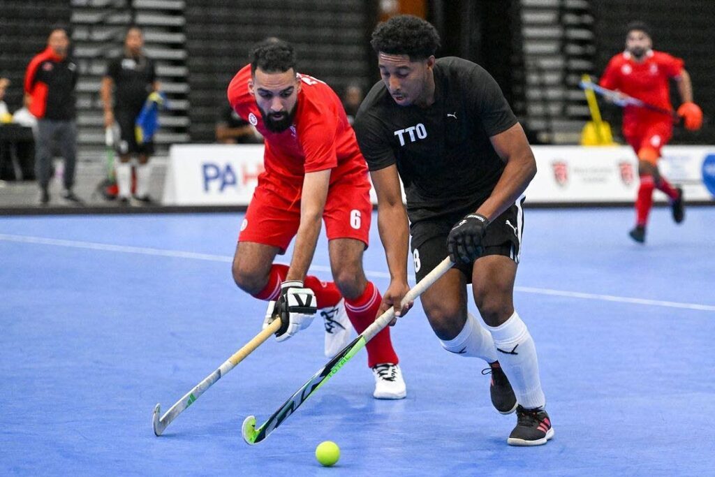 Trinidad and Tobago's Mickell Pierre (R) shields possession from his Canadian opponent during his team's first match of the 2024 Indoor Pan American Cup in Calgary, Canada on March 19. Photo courtesy Pan American Hockey Federation.  - 